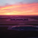 Explore the bustling Stansted Airport during sunset, highlighting its vibrant colors and busy atmosphere.