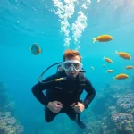 Tauchen Lernen in klarem Wasser mit einem Taucher, der die Grundlagen erlernt.