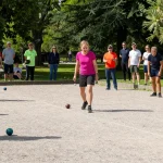 Kompetisi petanque di fopikotagorontal.org, pemain mengenakan pakaian kasual berpartisipasi dalam pertandingan di taman.